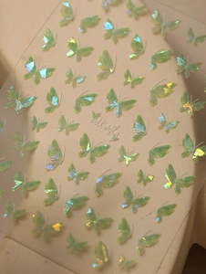 Macro shot of iridescent aurora butterfly nail stickers with green shell luster effects