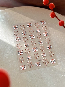 Detail of Chinese lion and gold firework nail art stickers on a beige stone surface