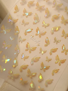 Macro shot of iridescent yellow butterfly nail stickers with laser shell finish for nail art