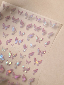 Macro shot of iridescent pink butterfly nail art stickers with laser holographic finish