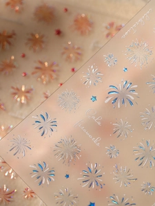 Macro view of holographic firework nail stickers with silver and gold metallic accents