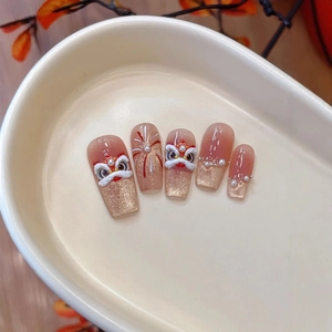 Long trapezoid press-on nails featuring Chinese lion dance motifs and champagne gold glitter