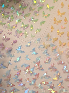 Close-up of holographic butterfly nail stickers with iridescent laser finish and model YT4559