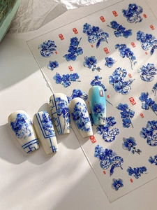 Detail of blue porcelain snake nail stickers with floral patterns and silver foil accents