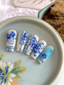 Detail of blue and white porcelain style nail art stickers with traditional flower patterns