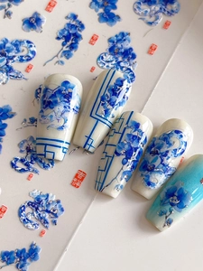 Macro detail of blue floral porcelain nail stickers with snake patterns and lucky seals