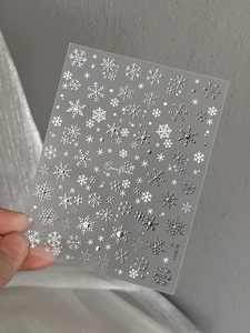 Macro detail of silver metallic snowflake nail art stickers with embossed texture YT4678