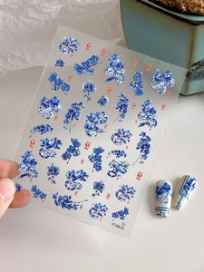 Macro detail of blue and white porcelain nail art stickers with dragon and floral patterns