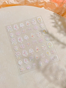 Detail of aurora laser nail stickers with pink bows and star designs on beige stone