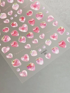 Dettaglio ravvicinato di adesivi per unghie fragola e cuore con arte ad acquerello
