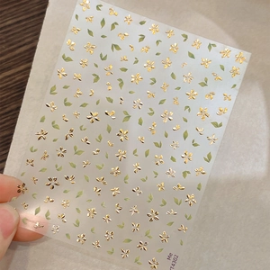 Self-adhesive nail art stickers featuring gold foil five-petal flowers and green leaves