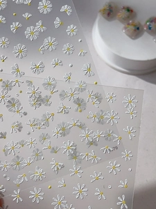 Macro view of 5D embossed daisy nail art stickers with intricate floral textures