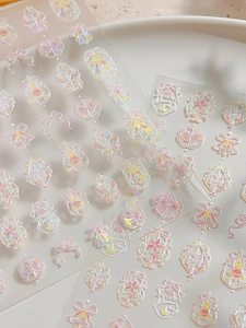 Detailed macro view of holographic pink bow nail stickers with laser sparkle effect