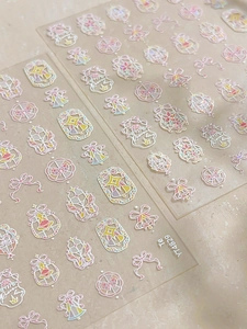 Detail of pink bow and star nail stickers with holographic shell finish and back adhesive