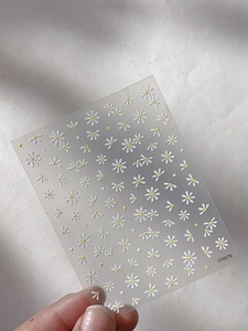 Macro shot of embossed white daisy nail stickers with yellow centers and 3D texture YT4978