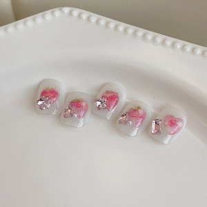 Unghie finte fatte a mano rosa con fragole, fiocchi 3D e perle su vassoio bianco