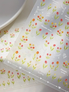 Vue macro de stickers ongles 3D tulipes et papillons avec motifs floraux printaniers