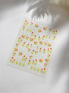 Gros plan de stickers à ongles avec des tulipes rouges et des papillons blancs