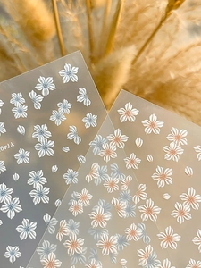 Macro detail of 3D embossed five-petal flower nail stickers with textured petal finish
