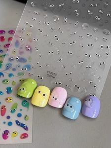 Macro detail of cute 3D jelly eyeball nail stickers applied on macaron color fake nails