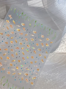 Detailed holographic nail stickers featuring gold fish and sparkling water grass designs