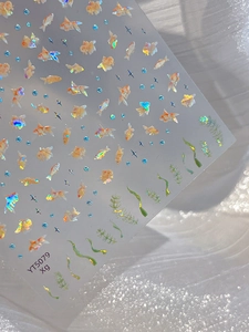 Detail of laser gold fish nail stickers with holographic shimmer effect on fabric base