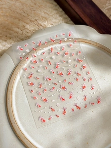 Detailed view of colorful koi fish and shell nail stickers on a ceramic plate