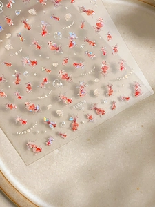 Detailed view of colorful goldfish nail art stickers with iridescent shell decorations