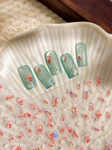 Detailed view of koi fish nail stickers with seashell accents and mint green gradient nails