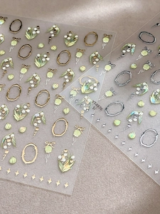 Détail d'autocollants pour ongles muguet avec cadres ovales gaufrés or et argent