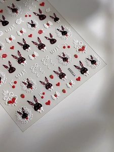 Makro-Detail der 3D-Prägung von Hasen- und Schleifen-Nagelstickern mit Relief-Textur