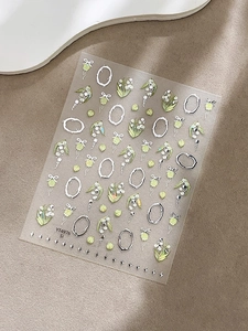 Détail d'autocollants pour ongles muguet avec cadres argentés gaufrés et cloches