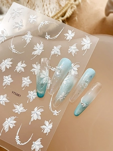 Detailed macro view of 5D white floral relief nail stickers with embossed flower patterns