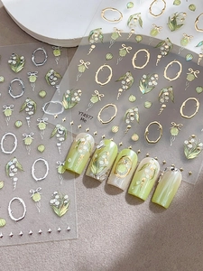 Détail des stickers ongles muguet avec motifs floraux délicats en or et en argent