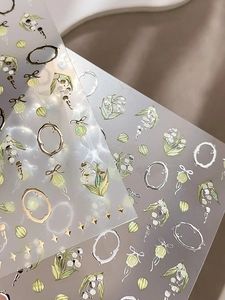 Vue macro d'autocollants pour ongles muguet avec détails métalliques dorés en relief 3D