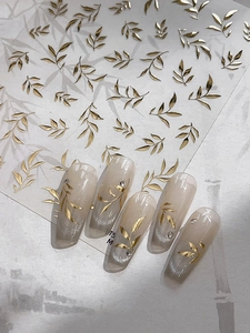 Détail de stickers à ongles feuilles dorées avec texture métallique et effet nail art 3D