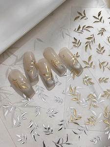 Vue détaillée de stickers à ongles feuilles dorées et argentées sur ongles taupe