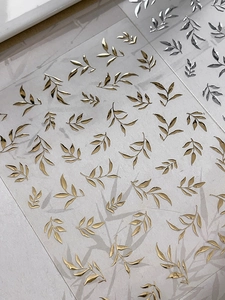 Détail de stickers à ongles feuilles or et argent avec motifs métalliques en relief