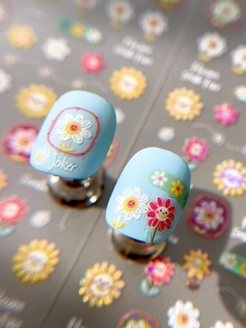 Macro shot of 3D embossed colorful sunflower nail art stickers with smiling faces