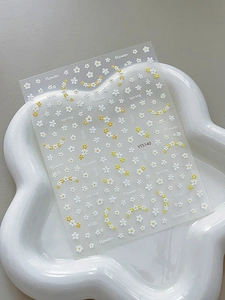 Detail of floral nail art stickers with white daisies and elegant spring calligraphy phrases