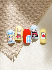 Detailed view of Alice in Wonderland theme press-on nails featuring hand-painted cartoon art