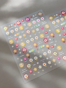 Detail view of sunflower nail stickers with embossed lines and colorful daisy motifs