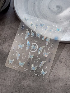 Iridescent butterfly and moon nail art stickers with holographic finish on dark background