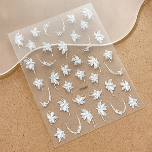 White embossed floral nail art stickers with maple leaf patterns on a frosted board