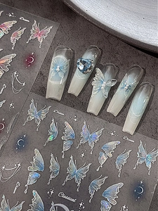 Macro detail of blue butterfly nail art stickers with 3D gems and iridescent finish