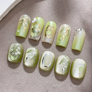 Faux ongles verts muguet avec art floral 3D et breloques papillon dorées élégantes