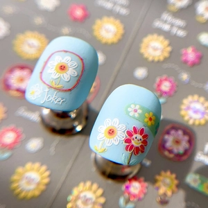 Sky blue matte fake nails with colorful sunflower stickers and daisy flower nail art