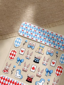 Macro detail of 3D embossed Alice in Wonderland nail stickers with cute rabbit patterns