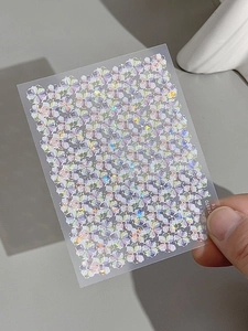Macro detail of laser holographic flower nail stickers with shimmering rainbow effects