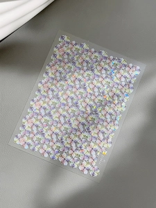 Macro detail of laser holographic floral nail art stickers with purple iridescent finish